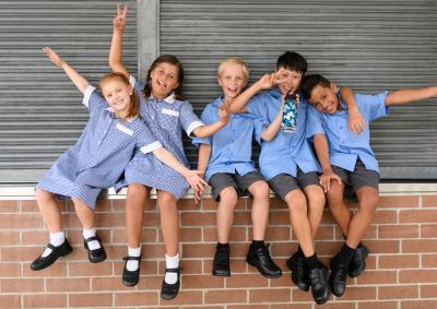 A group of young children in primary school smiling.