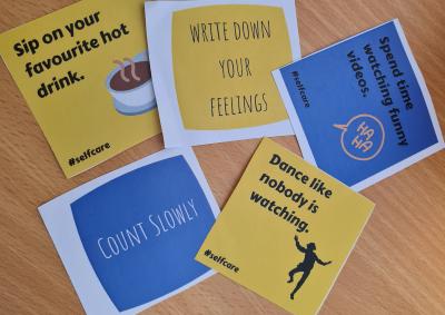 papers containing self care messages on a table