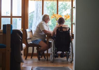 A women in a wheelchair and a man sitting at a table