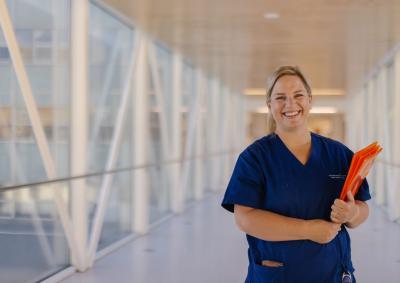 A nurse smiling in a corridor